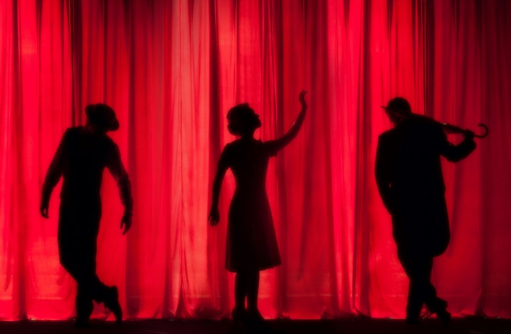 Silhouettes on stage curtain © Kyle Head | Unsplash