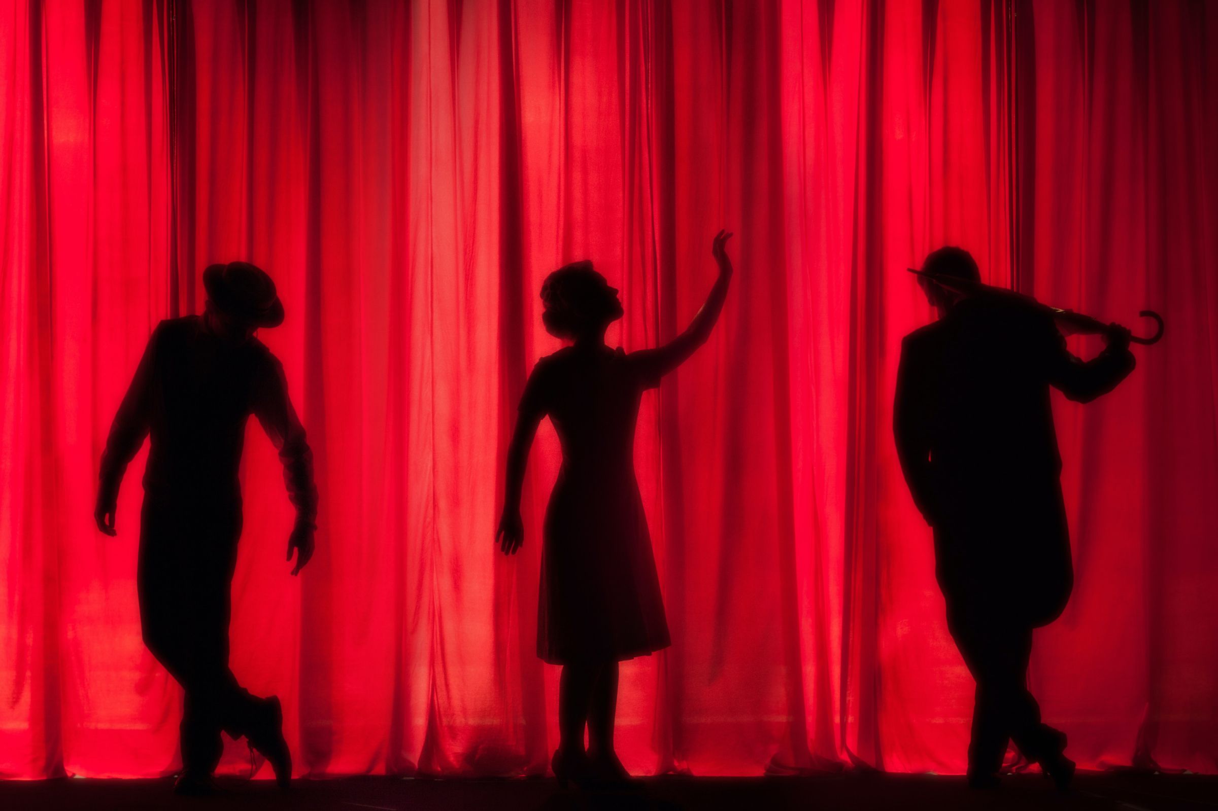 Silhouettes on stage curtain &copy; Kyle Head | Unsplash