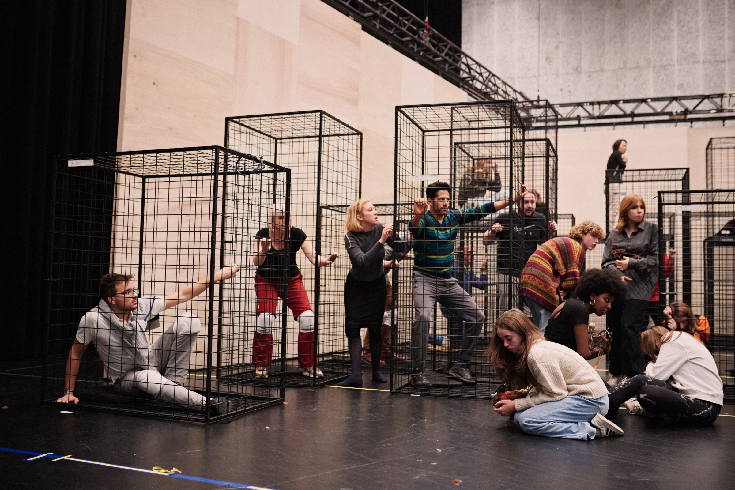 Cast and chorus rehearsing in cages &copy; Milagro Elstak