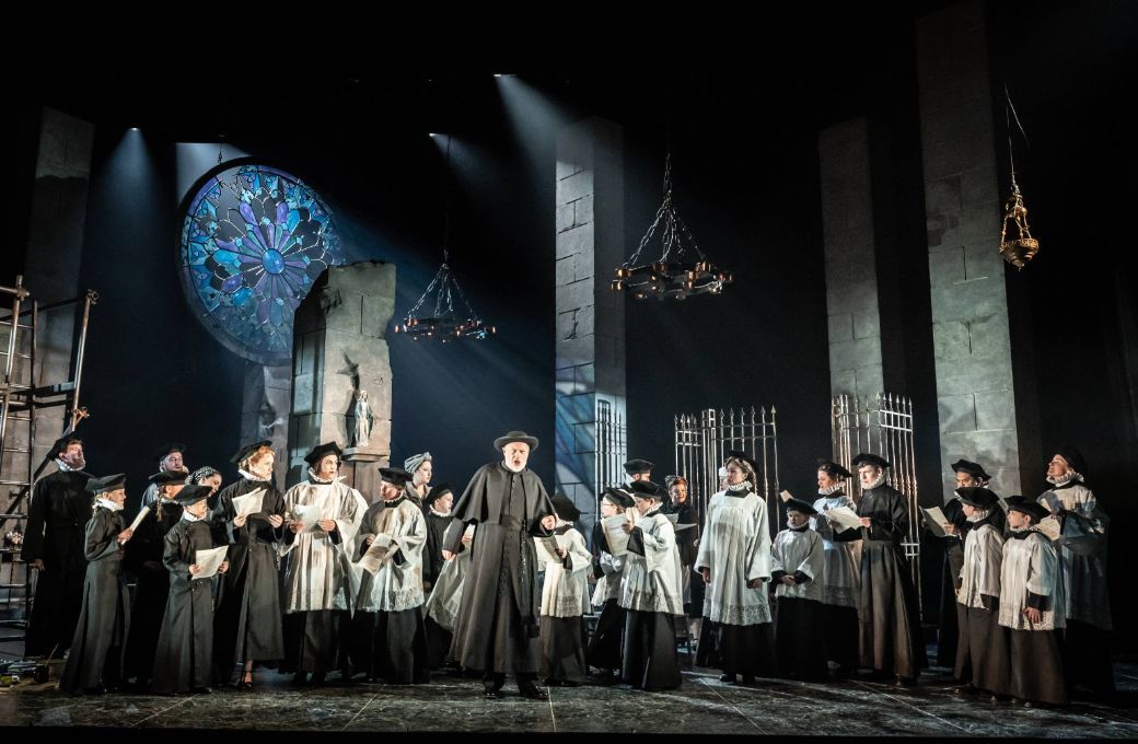 Andrew Slater (Sacristan) and the Grange Park Opera Chorus &copy; Marc Brenner