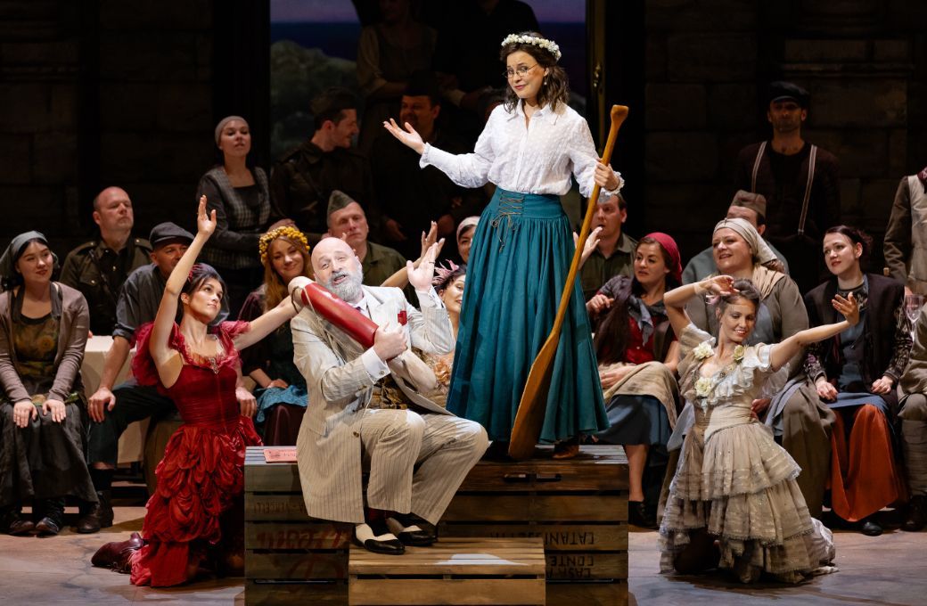 Peter Kálmán (Dulcamara), Lubov Karetnikova (Adina) and chorus © Agnese Zeltiņa | Latvian National Opera
