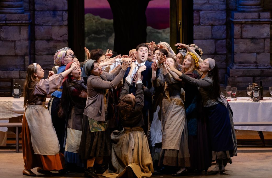 Mihails Čuļpajevs (Nemorino) and chorus &copy; Agnese Zeltiņa | Latvian National Opera