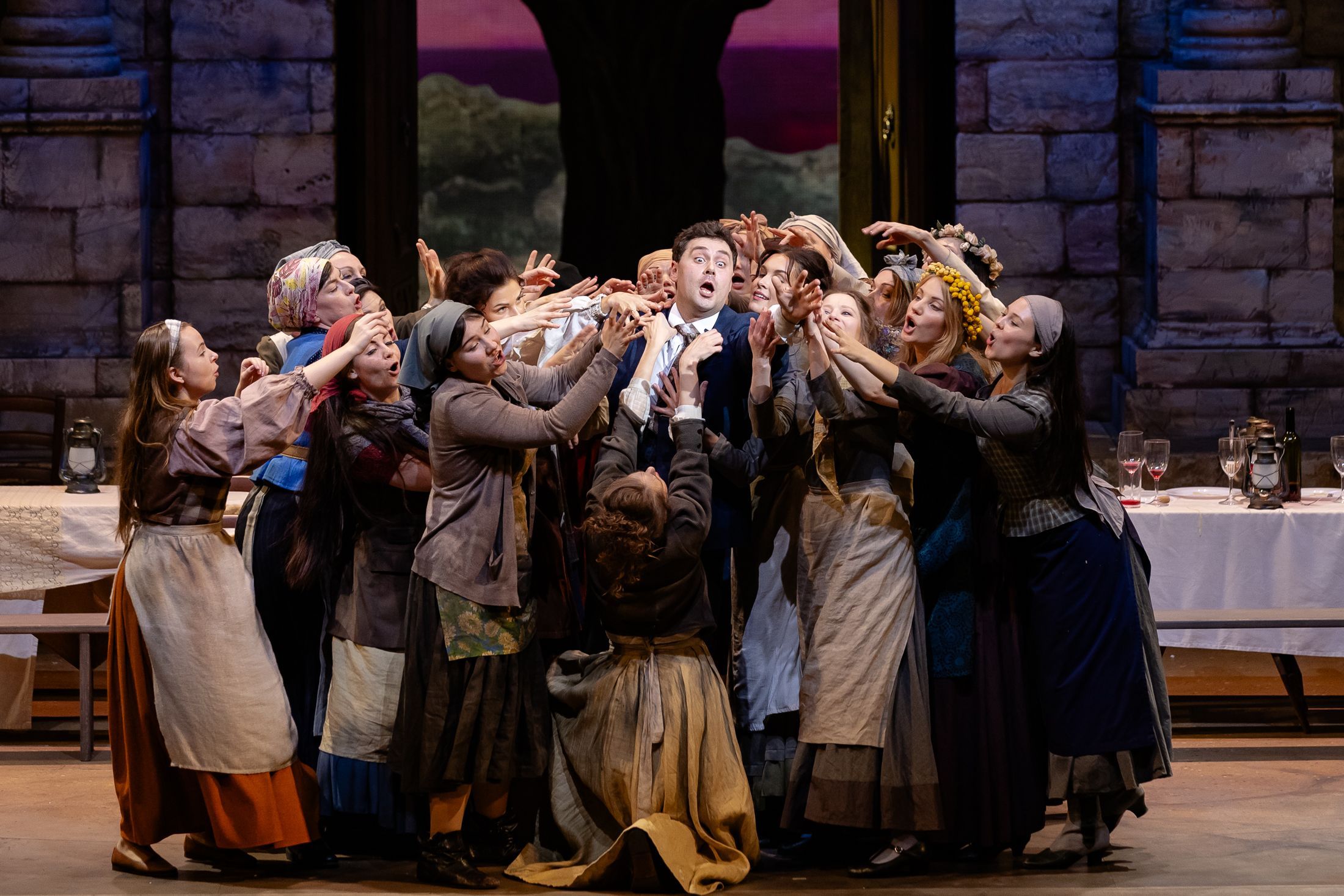 Mihails Čuļpajevs (Nemorino) and chorus &copy; Agnese Zeltiņa | Latvian National Opera